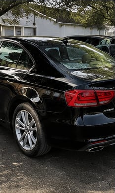 Same sedan after exterior detail, glossy clean finish